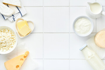 Fototapeta na wymiar Glass of milk, cottage cheese, ricotta, sour cream, cheese, camembert and butter on white table background. Different dairy products. Milk concept. Top view with copy space. Mock up.
