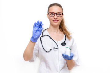 Friendly female doctor in white coat he holds pills in his hands and smiles, isolated on white background. Medical concept of young beautiful woman hospital worker looking at camera and smiling.