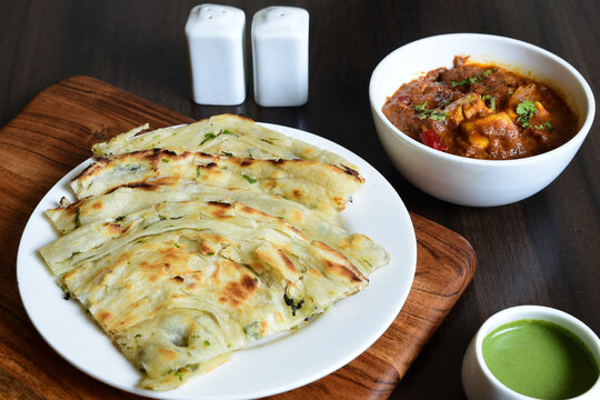 Closeup shot of Masala kulcha served with spicy paneer dish
