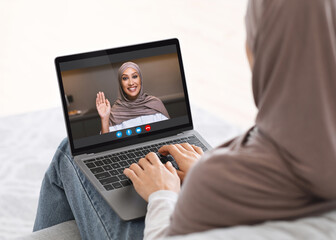 Online Communication. Two Muslim Women In Hijab Having Video Call Via Laptop