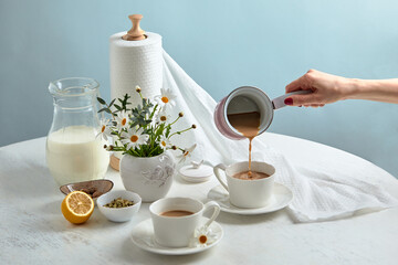 Breakfast is served on a table with light blue background. Breakfast setting over blue table with copy space border. Coffe with milk. Flat lay