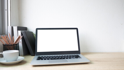 Fototapeta premium Laptop computer with white blank screen on wood desk. Workspace, workplace, desktop office concept.