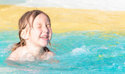 Happy child with closed eyes in the swimming pool for children.