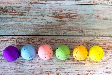 Easter eggs decorations over rustic colorful background. Colorful easter eggs on turquoise rustic wooden table. Easter, holidays, tradition, advertisement and object concept. Copy space.