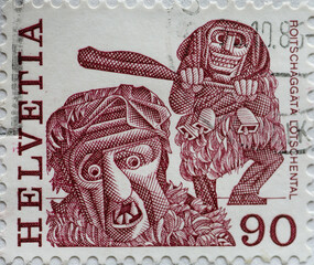 Switzerland - Circa 1977 : a postage stamp printed in the swiss showing  a New Year's Eve costume, Roitschäggätä Lötschenta