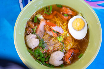 Closeup sukhothai Noodle with spicy soup in vintage bowl. Thai food style.
