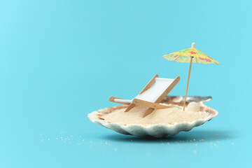 Tropical beach concept made of shall with sand, deck chair and sun umbrella. Creative summer vacation concept
