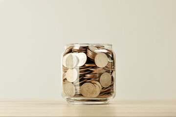 Many coins in a bottle on the table , saving money for future , loan investment concept , vintage...