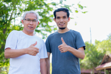 Fitness partners of different ages enjoyed and thumbs up while standing in the park.