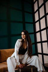 Fototapeta premium Fashion portrait of pretty sexy young brunette woman in white pantsuit
