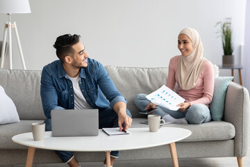 Young arab couple looking for health insurance on Internet