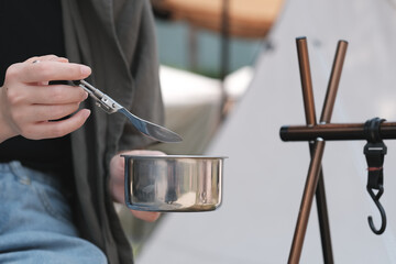 A woman eating something during camping.