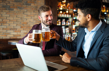 Business people drink beer after work. Businessmen enjoy a beer.