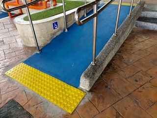 Concret ramp way with stainless steel handrail with disabled sign for support wheelchair disabled people.