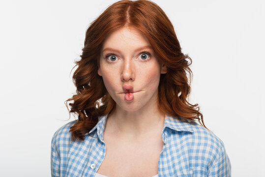 redhead woman in blue plaid shirt making fish face with lips isolated on white.