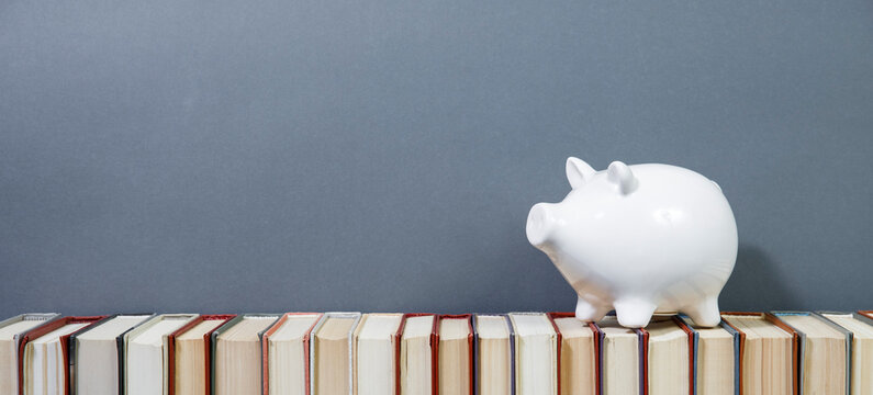 Composition with piggy bank and hardback books