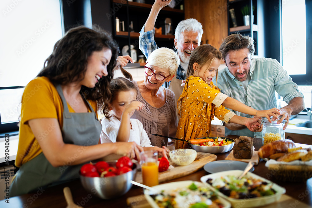 Wall mural Cheerful family spending good time together while cooking in kitchen