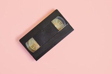 videotape on pink background, vintage video cassette copy space