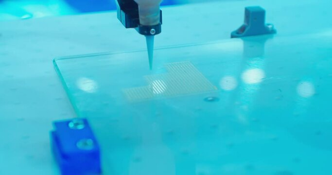 modern high-tech industrial equipment.the dispenser robot works with a small microcircuit board.close-up.
