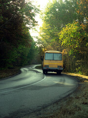 Fototapeta na wymiar Road with school bus in beautiful summer forest.