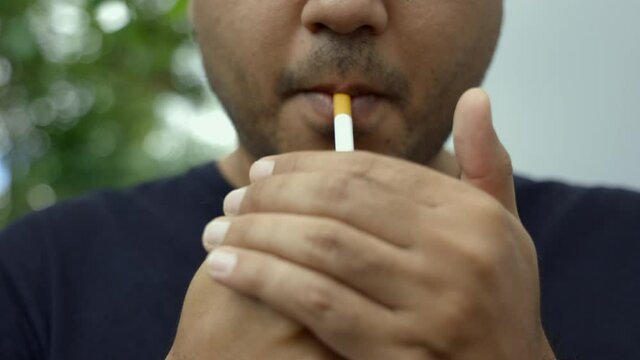 Young men smoking He smoked and spat out a lot of smoke. It is dangerous to the people around. World No Tobacco Day.