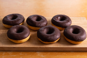 Chocolate donuts on a wood background