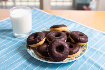 Chocolate donuts and milk, typical breakfast food.