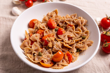 Pasta with tuna, cherry tomatoes and capers. Typical italian dish idea.