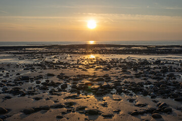 Whiteford sands beach stones at sunset, the Gower peninsula, Swansea, South Wales, UK. Coastline backdrop, no people