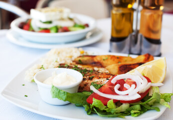 Greece food - Grilled salmon and vegetables on white plate