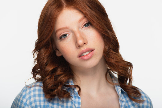 redhead woman in blue plaid shirt looking at camera isolated on white.