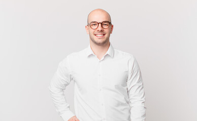 bald man smiling happily with a hand on hip and confident, positive, proud and friendly attitude