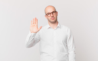 bald man looking serious, stern, displeased and angry showing open palm making stop gesture