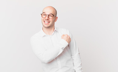 bald man feeling happy, positive and successful, motivated when facing a challenge or celebrating...
