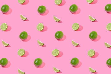 Sunlight summer pattern made with fresh green lime on bright pink background. Creative tropical concept.