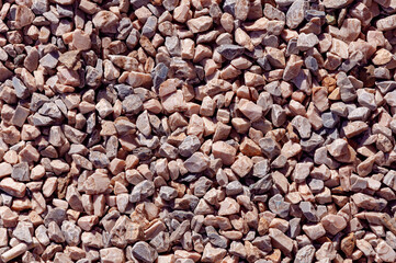 Sharp granite rocks background in a sunny day. Fine gravel rocks texture for design. Pieces crushed gravel for the construction industry