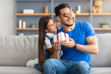 Loving girl celebrating father's day, greeting excited dad with box