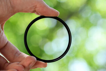 Hand hold  safety filter  for the lens against blue sky. Light background
