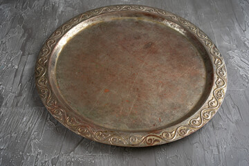 Old retro metal tray on a black stone background. Top view. Free copy space.