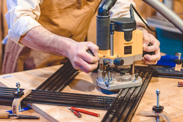 detail of a carpenter using a router