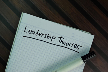 Leadership Theories write on a book isolated on Wooden Table.