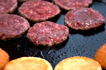Cutlets and burger buns fried in a pan, street food