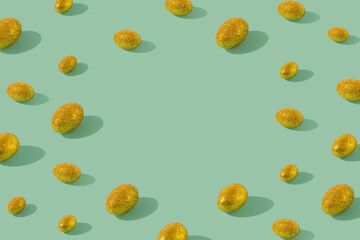 Easter gold eggs pattern made with gold glitter eggs on mint background. Minimal natural concept with copy space.