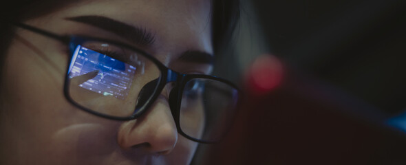 A business woman is using a phone to look at price data on digital financial systems.