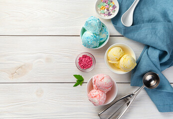 Three types of creamy fruit ice cream and sweet additives on a white background.