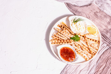 Grilled scorzonera with sauces set with modern hard light, dark shadow