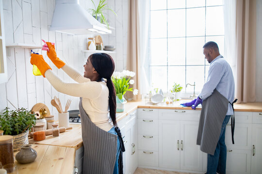 Millennial Black Couple Cleaning Their Kitchen Together, Enjoying Household Duties, Free Space. Housecleaning Service