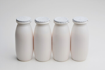 Natural liquid yogurt with probiotics in small plastic bottles on white background. Healthy, balanced diet food, healthy breakfast, dairy products. Selective soft focus, blurred background.