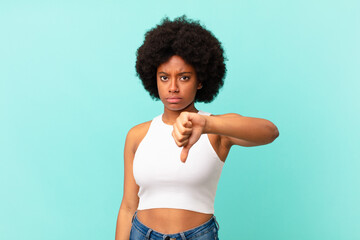 afro black woman feeling cross, angry, annoyed, disappointed or displeased, showing thumbs down...