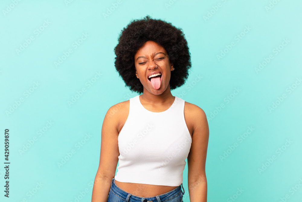 Wall mural afro black woman with cheerful, carefree, rebellious attitude, joking and sticking tongue out, having fun